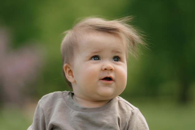 Een close portret van een kind van 7 maanden dat in de wei speelt