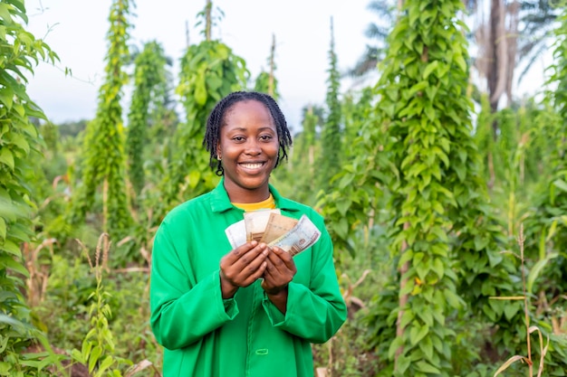 Een close-up shot van een gelukkige Afrikaanse boerin in Nigeria die wat geld vasthoudt