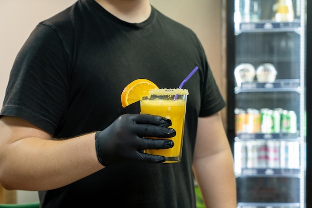 Een close-up van de barman die een glas sinaasappeldrank vasthoudt in een sportcomplex