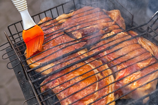 Een close-up van de taarten van entrecote-varkensvlees in teriyakisaus wordt gebakken in een grill