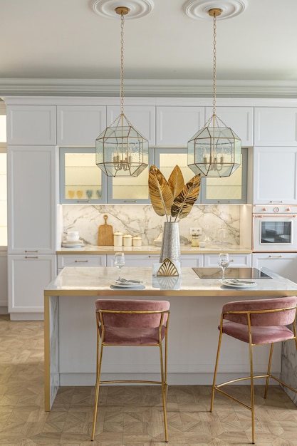 Een close-up van de witte stijlvolle keuken met kookeiland in het luxe interieur van een modern appartement in lichte kleuren met stijlvol meubilair