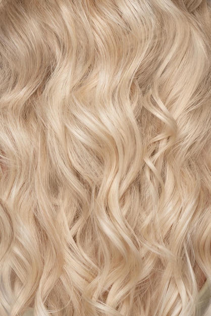 Een close-up van een bos glanzende krullen blond haar