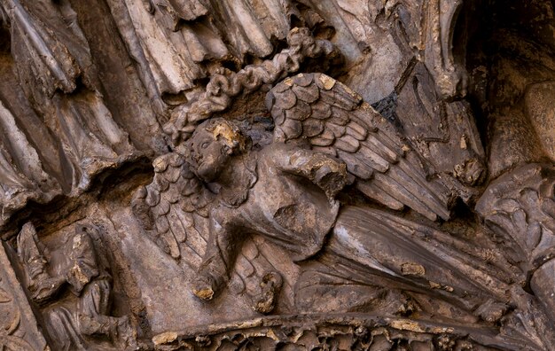 Een close-up van een gesneden houten sculptuur van een engel met een kroon op zijn hoofd.