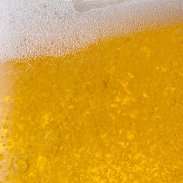 Een close-up van een Gietend bier met schuim. ideaal voor lay-outs van websites en tijdschriften