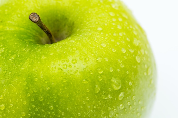 Een close-up van een groene appel met waterdrops geïsoleerd op een witte achtergrond. Genomen in Studio met een 5D mark III.