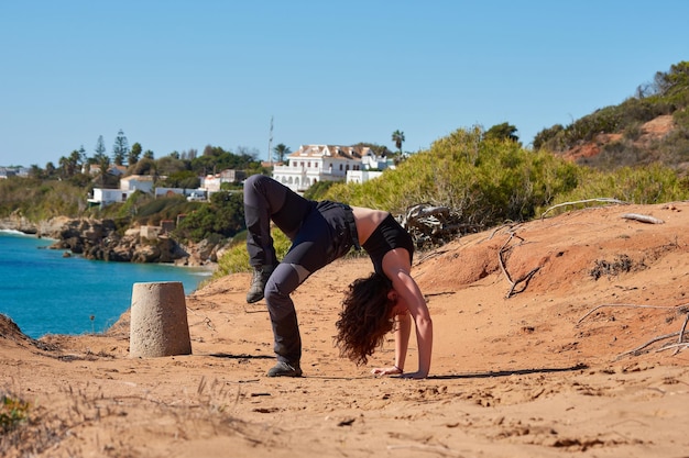 Een close-up van een jonge vrouw die yoga doet in de buurt van het strand in Spanje