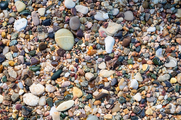 Een close-up van een strand met rotsen en kiezels