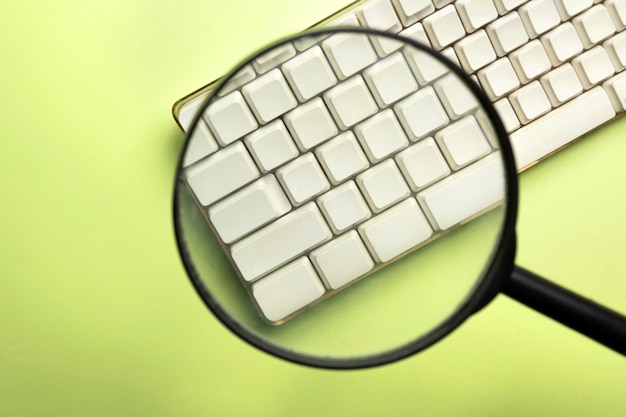 Foto een close-up van een vergrootglas richt zich op een toetsenbordknop van de computer