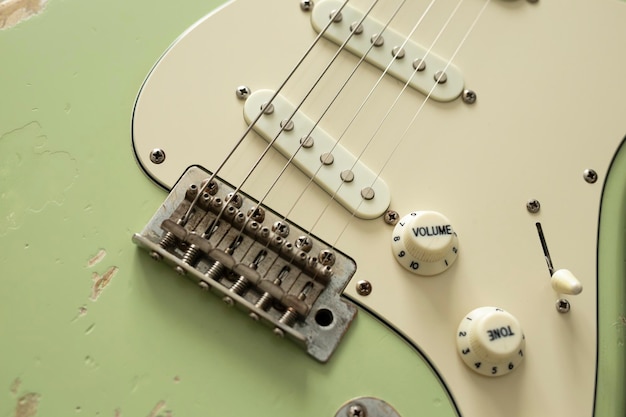 Een close-up van een witte elektrische gitaar met het volume bovenaan.