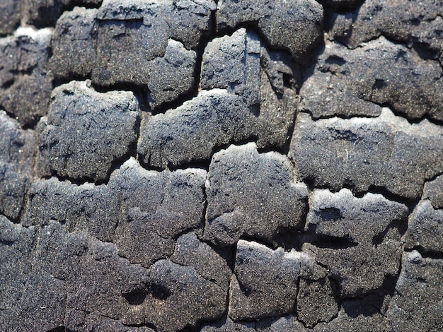 Een close-up van een zwarte lavasteen waarop de zon schijnt.