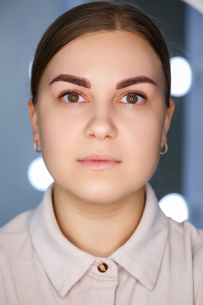 Een close-up van het gezicht van een jonge vrouw die net een permanente wenkbrauwtatoeage heeft laten zetten.
