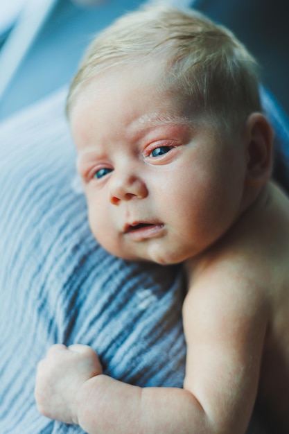 Een close-up van het gezicht van een pasgeboren baby. Een pasgeboren baby kijkt naar de camera Open ogen van een pasgeboren baby