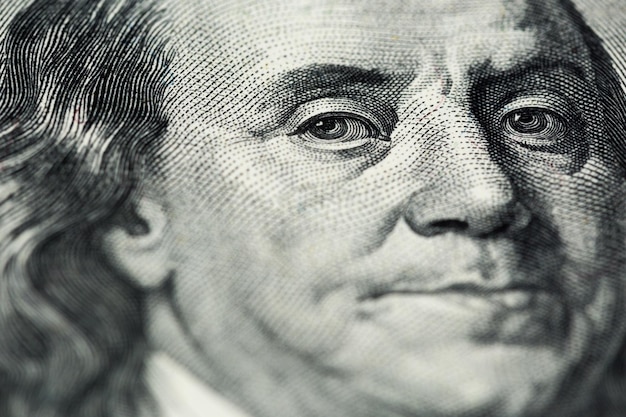 Een close-up van het saaie portret van Ben Franklin van een oud bankbiljet van honderd Amerikaanse dollars