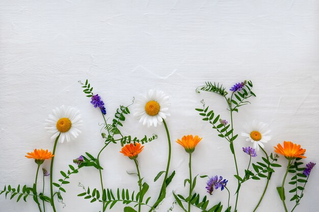 Een compositie van bloemen op een lichte houten ondergrond