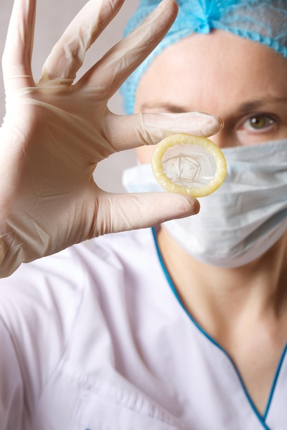 Een condoom in de hand van een dokter. Detailopname