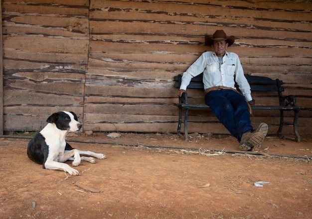 Een Cubaanse boer en zijn hond rusten uit bij de ingang van een typisch landelijk huis in Cuba