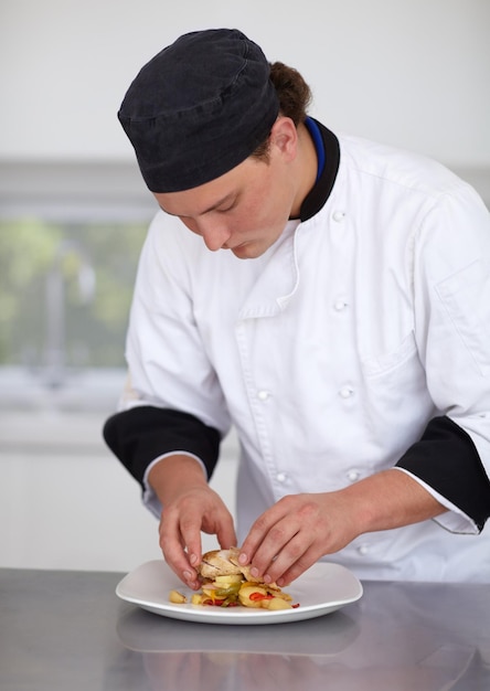 Een culinair meesterwerk creëren Jonge chef-kok bereidt een kipschotel in een keuken Fine Dining