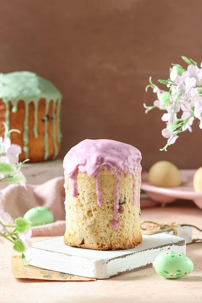 Een cupcake met roze en paars glazuur erop staat op een marmeren ondergrond.