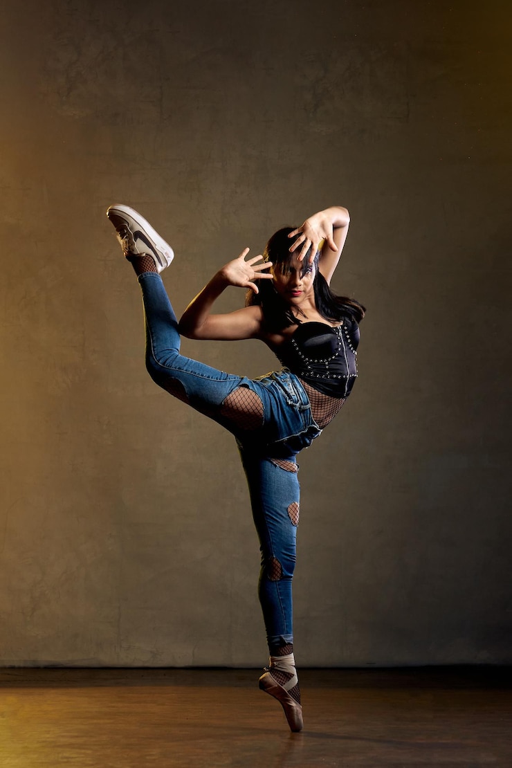 Foto een danseres in een zwart shirt en spijkerbroek poseert voor een foto.