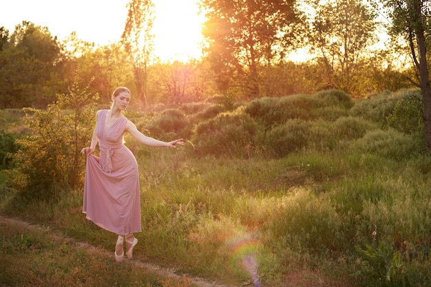 Een danseres in pointe-schoenen in de natuur bij zonsondergang Banner