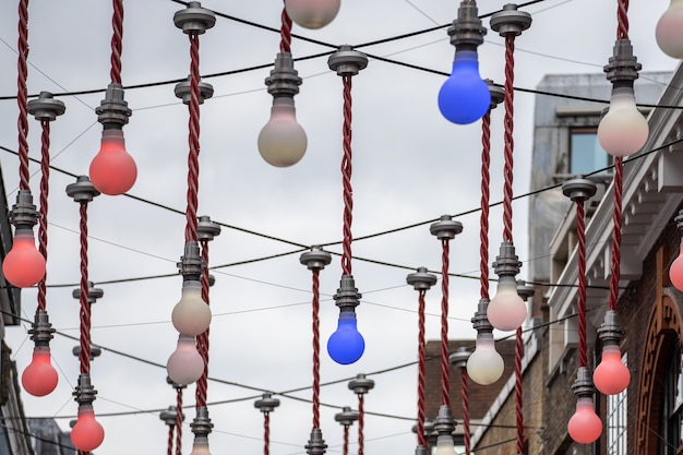 Een decoratieve weergave van grote gloeilampen die boven de kruising van Ganton Street en Carnaby Street in Soho hangen