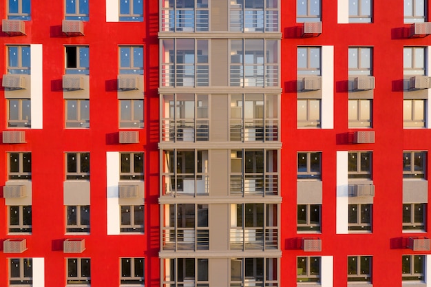 Een deel van de gevel met ramen van een nieuw huis met rode muren