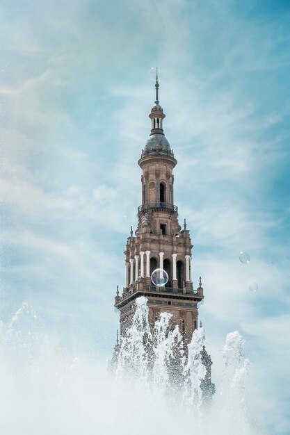 Een deel van de toren op Plaza de Espana in Sevilla met achterlating van een waterstraal behorend tot de fontein