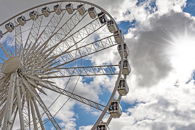 Een deel van een groot reuzenrad op een bewolkte hemelachtergrond