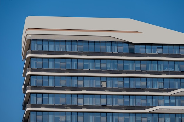 Een deel van moderne stedelijke gebouwen met gemengd glas bevindt zich in de blauwe lucht en bij mooi weer