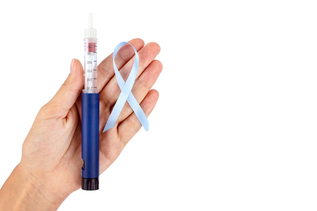 Een diabetische spuitpen met een naald een blauw lint is een symbool van Wereld Diabetes Dag het is geïsoleerd