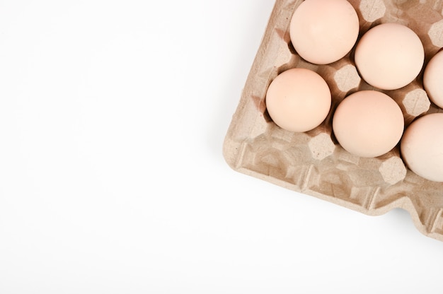 Een dienblad met eieren op een witte tafel. eco dienblad met eieren op een witte achtergrond, de trend van minimalisme, bovenaanzicht. Eiertray