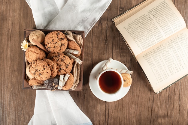 Een dienblad met koekjes en een kopje thee. bovenaanzicht