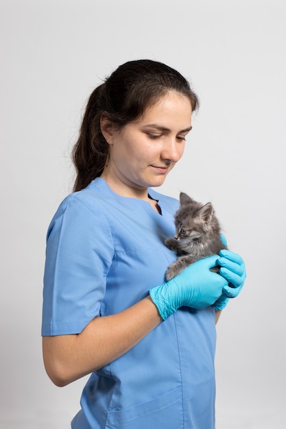 Een dierenarts die een klein katje vasthoudt