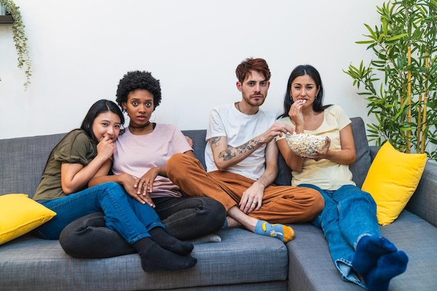 Een diverse groep vrienden die thuis een film kijken en waarop verschillende reacties te zien zijn