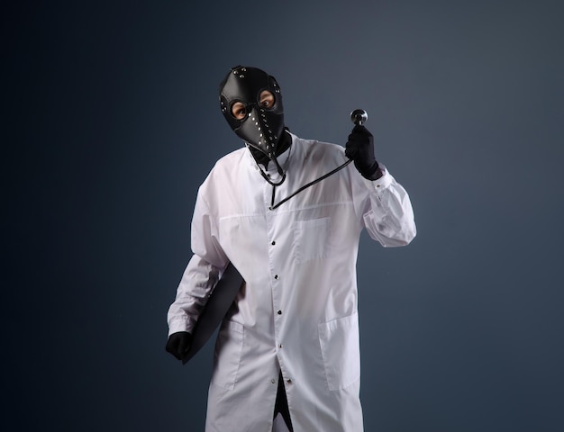 Een dokter in een kamerjas die een pestdoktermasker draagt met een stethoscoop in zijn handen