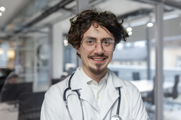 Een dokter in een witte medische jas staat in zijn kantoor met een stethoscoop man dichtbij kijken