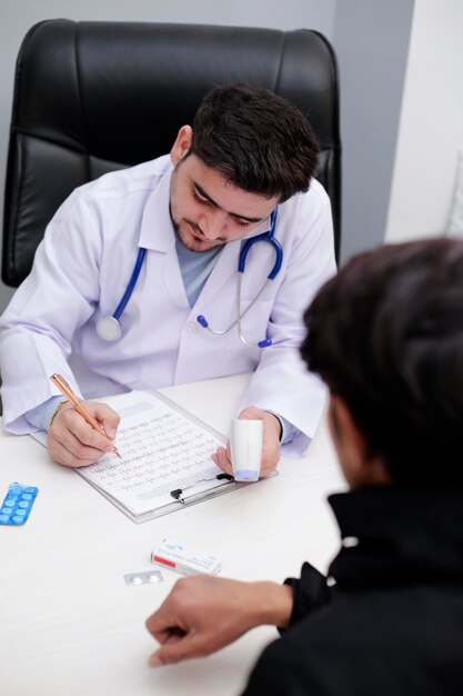 Een dokter zit aan een bureau met een klembord waarop 'medicijn' staat