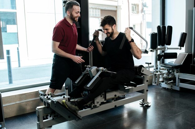 Een donkerharige man die been traint met zijn personal trainer