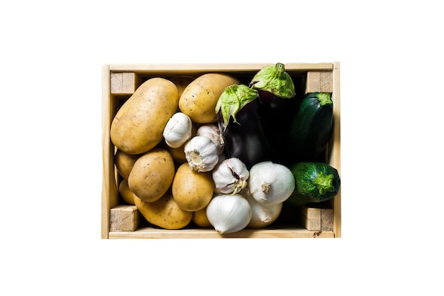 Een doos groenten aardappelen uien knoflook aubergine courgette Supermarkt geïsoleerd op een witte achtergrond