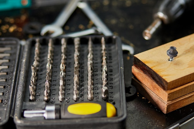 Een doos met metalen stalen koppen en bits met verschillende soorten voor schroevendraaier