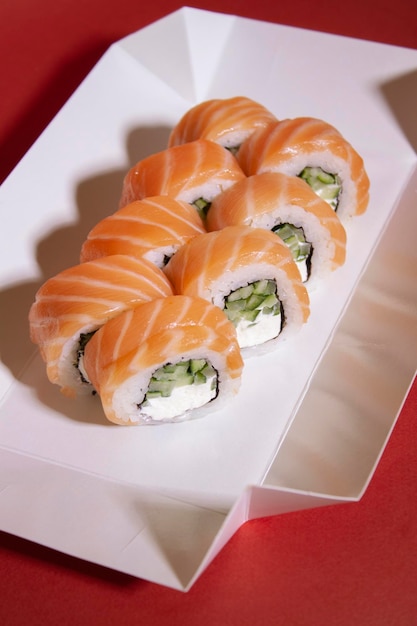 Foto een doos sushi met een wit papier eronder.