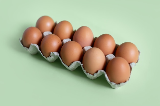 Een dozijn eieren in een doos op een groene achtergrond