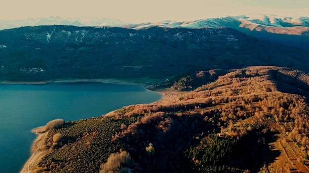 Een drone vangt de rustige schoonheid van een bergachtig winterlandschap met het kalme water