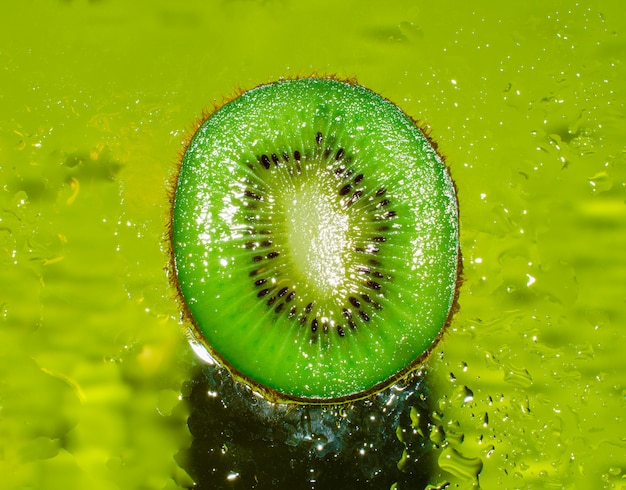 Een dwarsdoorsnede van sappige kiwi op een groene achtergrond