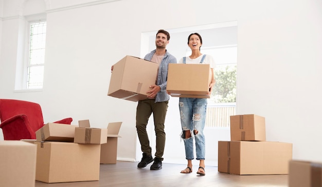 Een echtpaar draagt dozen naar een nieuw huis op de dag van de verhuizing