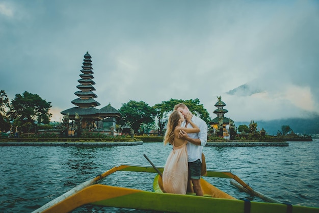 Foto een echtpaar in een outriggerboot op het meer tegen de tempel