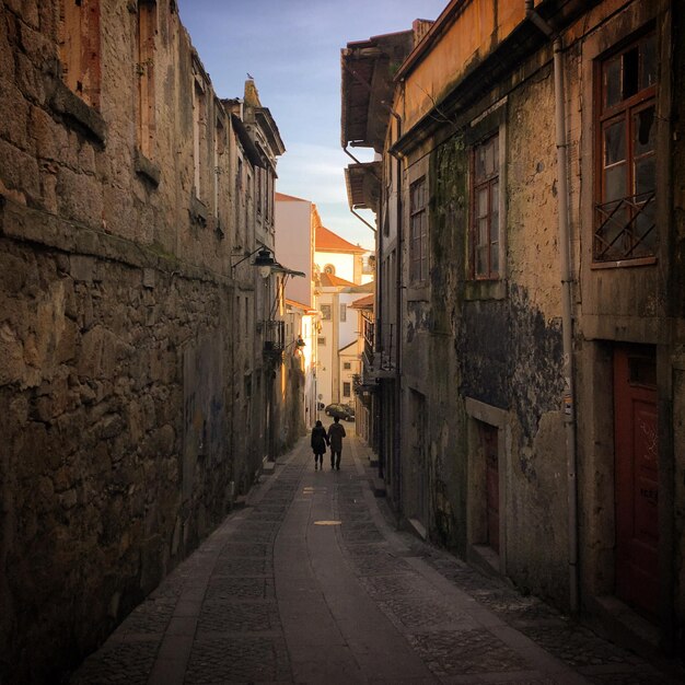 Een echtpaar loopt door een smalle straat in Porto, Portugal, januari 2019