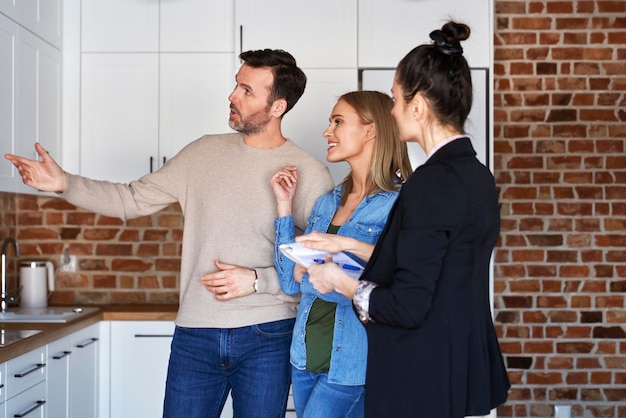 Een echtpaar met een makelaar die een nieuw appartement bekijkt