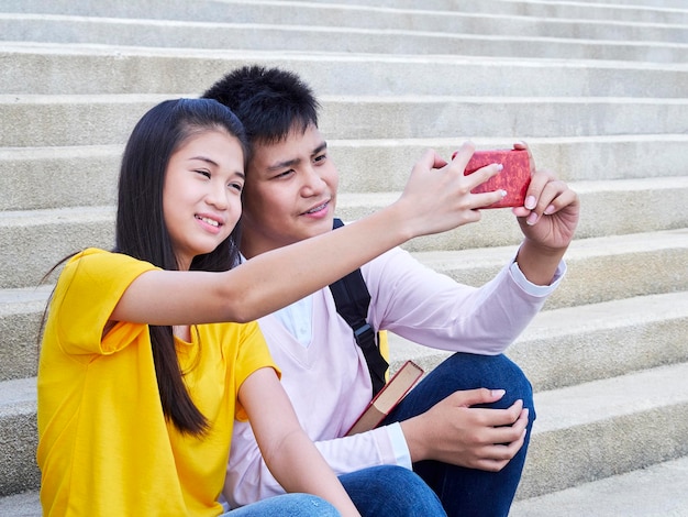 Een echtpaar neemt een selfie terwijl ze op de trappen zitten.