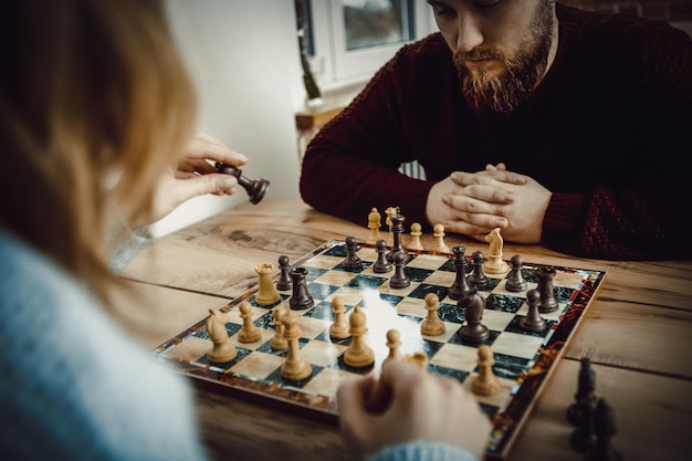 Een echtpaar speelt schaak op tafel thuis.